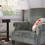 A warm gray chair creates a cozy reading place.